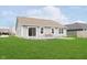 The home's backyard features a concrete patio, well-kept lawn, and neutral vinyl siding at 6467 W Whispering N Way, Greenfield, IN 46140
