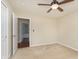 This bedroom features a ceiling fan, neutral walls, and an open doorway at 6467 W Whispering N Way, Greenfield, IN 46140
