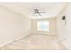A spacious bedroom with neutral carpet, a ceiling fan and a window letting in natural light at 6467 W Whispering N Way, Greenfield, IN 46140