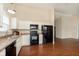 Bright eat-in kitchen with updated countertops and flooring featuring black appliances at 6467 W Whispering N Way, Greenfield, IN 46140