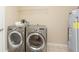 A functional laundry room with washer, dryer, water heater, and overhead shelving at 6467 W Whispering N Way, Greenfield, IN 46140