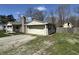 Exterior view of a home with a detached garage and gravel driveway at 6672 E 225 S, Whitestown, IN 46075