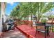 Red back deck with table and chairs, grill, and a view of the backyard at 6869 W Winding, McCordsville, IN 46055