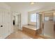 Well lit bathroom features a tile floor, glass-enclosed shower, and tiled soaking tub at 6869 W Winding, McCordsville, IN 46055