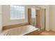 Elegant bathroom featuring a soaking tub, glass-enclosed shower, and natural light at 6869 W Winding, McCordsville, IN 46055