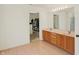 Bright bathroom with double sinks, wood cabinets, and a doorway to a walk-in closet at 6869 W Winding, McCordsville, IN 46055
