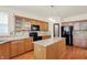 Traditional kitchen featuring wood cabinets, granite counters, a black refrigerator, and an island at 6869 W Winding, McCordsville, IN 46055