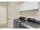 Laundry room with modern washer and dryer units and convenient white overhead storage at 6869 W Winding, McCordsville, IN 46055