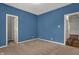 This bedroom features neutral carpeted floors and two doorways at 701 Downing Dr, Greenwood, IN 46143