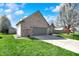 Angle view of a brick home with a garage, complemented by a green lawn at 701 Downing Dr, Greenwood, IN 46143