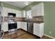 Well-lit kitchen featuring white cabinetry, stainless steel appliances and tiled backsplash at 701 Downing Dr, Greenwood, IN 46143