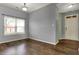 Open living room with hardwood floors, natural light, and neutral paint at 701 Downing Dr, Greenwood, IN 46143