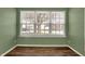 Sunlit room with hardwood floors and a large window view of the neighborhood at 701 Downing Dr, Greenwood, IN 46143