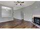 Open-concept living room featuring a fireplace, hardwood floors and view into the dining room at 701 Downing Dr, Greenwood, IN 46143
