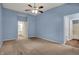 Bright main bedroom featuring a ceiling fan, neutral carpet, and ensuite bathroom at 701 Downing Dr, Greenwood, IN 46143