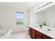 Bright bathroom with double sinks, wood cabinetry, and lots of natural light at 7048 Millet Ln, Avon, IN 46123