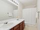 Bright bathroom featuring double sinks, a large mirror, and a shower with a white curtain at 7048 Millet Ln, Avon, IN 46123