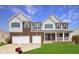 Inviting two-story home with a brick facade, two-car garage, and covered front porch at 7048 Millet Ln, Avon, IN 46123