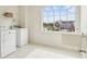Sunlit laundry room with new washer, dryer, utility sink, and large window at 7048 Millet Ln, Avon, IN 46123