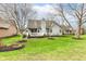 Well-maintained backyard with a wooden deck, landscaping, and lush lawn, perfect for outdoor entertaining at 7242 River Glen Dr, Fishers, IN 46038