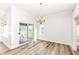 Bright dining area with wood floors, chandelier, and sliding glass doors leading to an outdoor patio at 7242 River Glen Dr, Fishers, IN 46038