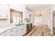 Bright, open kitchen with white cabinets, stainless appliances, and hardwood floors at 7242 River Glen Dr, Fishers, IN 46038