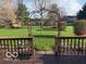 Expansive backyard view featuring lush green grass and metal garden archway from wooden deck at 7664 Lincoln Trl, Plainfield, IN 46168