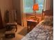 Traditional bedroom with wood furnishings, including rocking chair, side table with lamp, and a bed with decorative quilt at 7664 Lincoln Trl, Plainfield, IN 46168