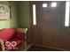 Inviting foyer with hardwood front door and a decorative love seat at 7664 Lincoln Trl, Plainfield, IN 46168