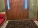 Classic wood front door with decorative glass sidelights and a patterned area rug at the entrance at 7664 Lincoln Trl, Plainfield, IN 46168