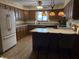 Eat-in kitchen with wooden cabinets, laminate floor, and a decorative stained glass style light fixture at 7664 Lincoln Trl, Plainfield, IN 46168