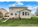 Backyard featuring a well-maintained lawn and a two-story home with beige siding at 7736 Eagle Point Cir, Zionsville, IN 46077