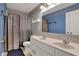 Bathroom featuring a double sink vanity, toilet, shower with curtains, and decorative mirror at 7736 Eagle Point Cir, Zionsville, IN 46077