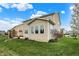 Beige two-story home exterior with multiple windows, a well-manicured lawn, and a sunroom addition at 7736 Eagle Point Cir, Zionsville, IN 46077