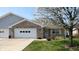 Charming brick home featuring an attached garage, well-maintained lawn, and lovely flowering tree in the front yard at 8142 Bentley Farms Dr, Indianapolis, IN 46259