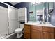 This bathroom has blue walls, a white shower, and a wood vanity at 8810 Yardley Ct # 208, Indianapolis, IN 46268