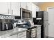 Modern kitchen features stainless steel appliances, white cabinets, and mosaic backsplash at 8810 Yardley Ct # 208, Indianapolis, IN 46268