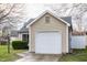 Frontal view of the garage with a white door and well-manicured landscaping at 9223 Steeplechase Dr, Indianapolis, IN 46250