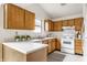 Well-lit kitchen featuring wood cabinets, white appliances, and plenty of counter space for cooking at 9223 Steeplechase Dr, Indianapolis, IN 46250