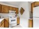 Kitchen featuring wood cabinets, white appliances, and a woven basket at 9223 Steeplechase Dr, Indianapolis, IN 46250
