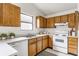 A functional kitchen featuring wood cabinets, a white dishwasher, and plenty of counter space at 9223 Steeplechase Dr, Indianapolis, IN 46250