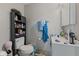 The bathroom has white walls, a white toilet and sink, and a black storage shelf at 9448 Burrwood Cir, Indianapolis, IN 46235