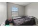 A secondary bedroom featuring wood-look floors, a window, and a dark bedspread at 9448 Burrwood Cir, Indianapolis, IN 46235