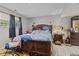 View of the primary bedroom featuring natural light and an ornate, dark wood bed frame at 9448 Burrwood Cir, Indianapolis, IN 46235