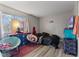 A secondary bedroom with wood-look floors, neutral walls, and colorful furnishings at 9448 Burrwood Cir, Indianapolis, IN 46235