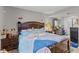The primary bedroom has tiled floors, neutral walls, and a large wood bed frame at 9448 Burrwood Cir, Indianapolis, IN 46235