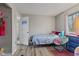 A secondary bedroom with wood-look floors, neutral walls, and colorful furnishings at 9448 Burrwood Cir, Indianapolis, IN 46235