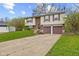 Two-story home with a brick facade, a two-car garage, and a well-manicured lawn at 9448 Burrwood Cir, Indianapolis, IN 46235