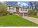 Two-story home with a brick facade and two-car garage with a lawn in the front yard at 9448 Burrwood Cir, Indianapolis, IN 46235