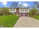 Split-level home featuring a two-car garage, brick accents, and a well-maintained front lawn at 9448 Burrwood Cir, Indianapolis, IN 46235